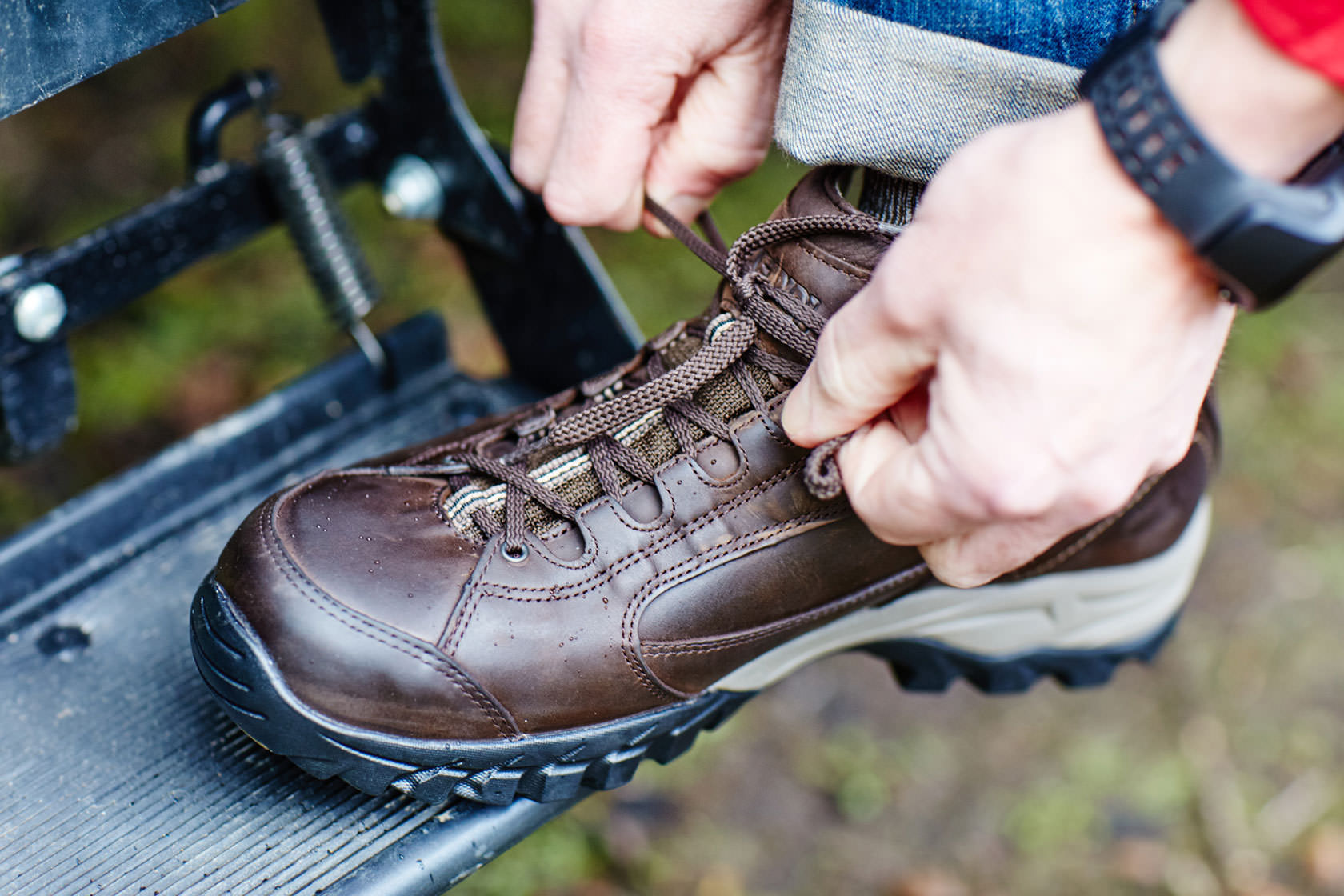 A boot being tied on a rock