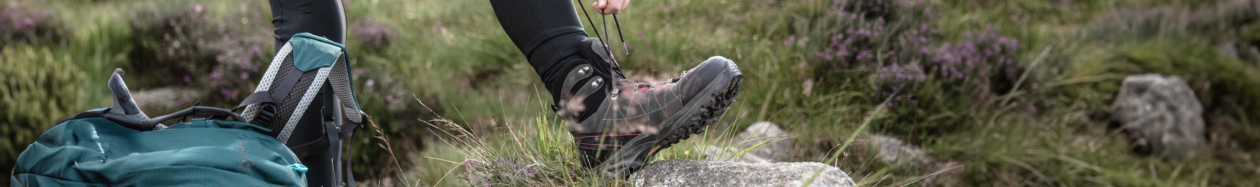 A person tying up the laces of their waterproof walking boots