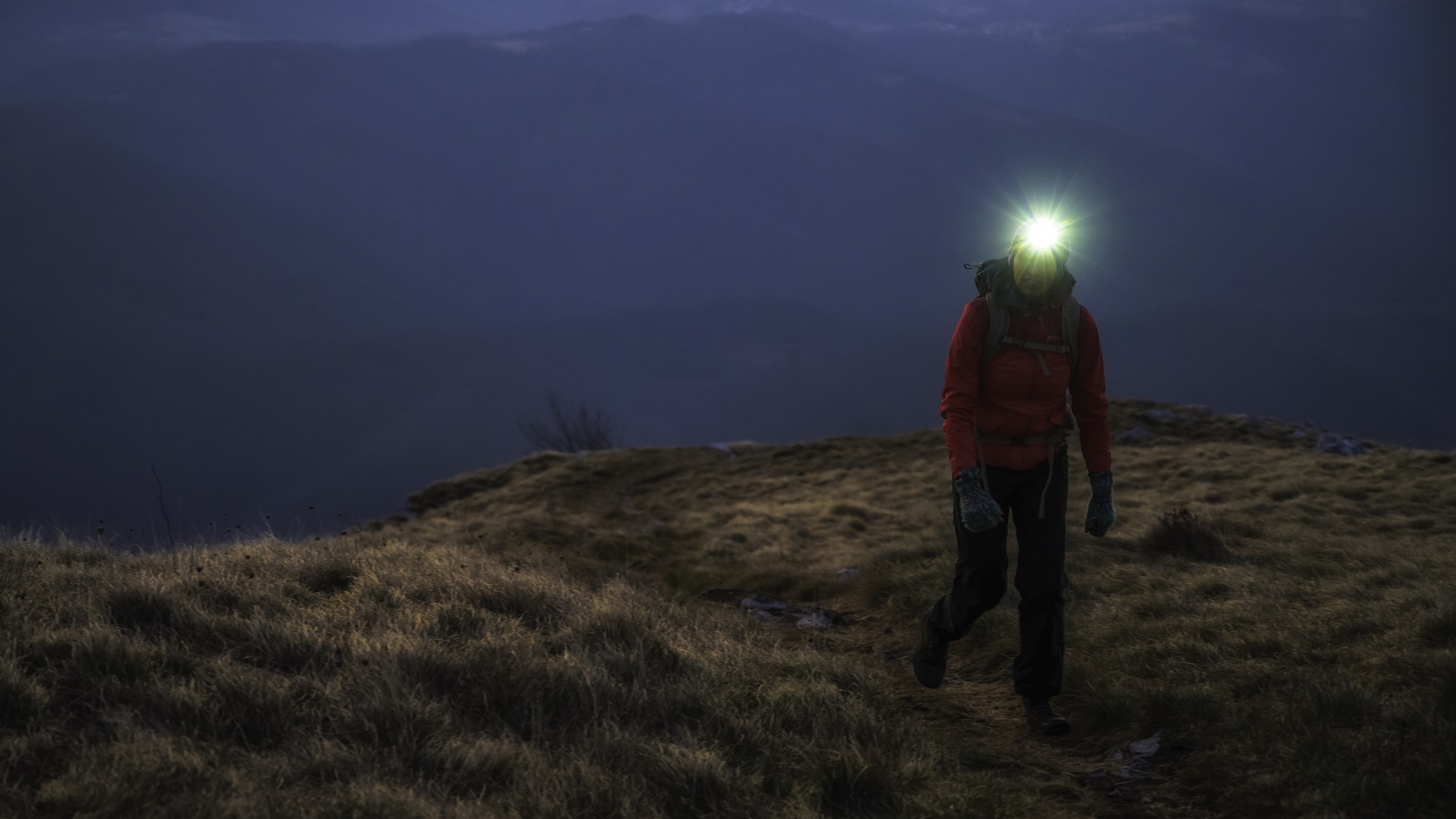A person wearing a head torch in the dark 