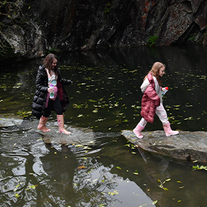 Two people walking by the water
