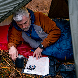 Man having his coffe inside his tent