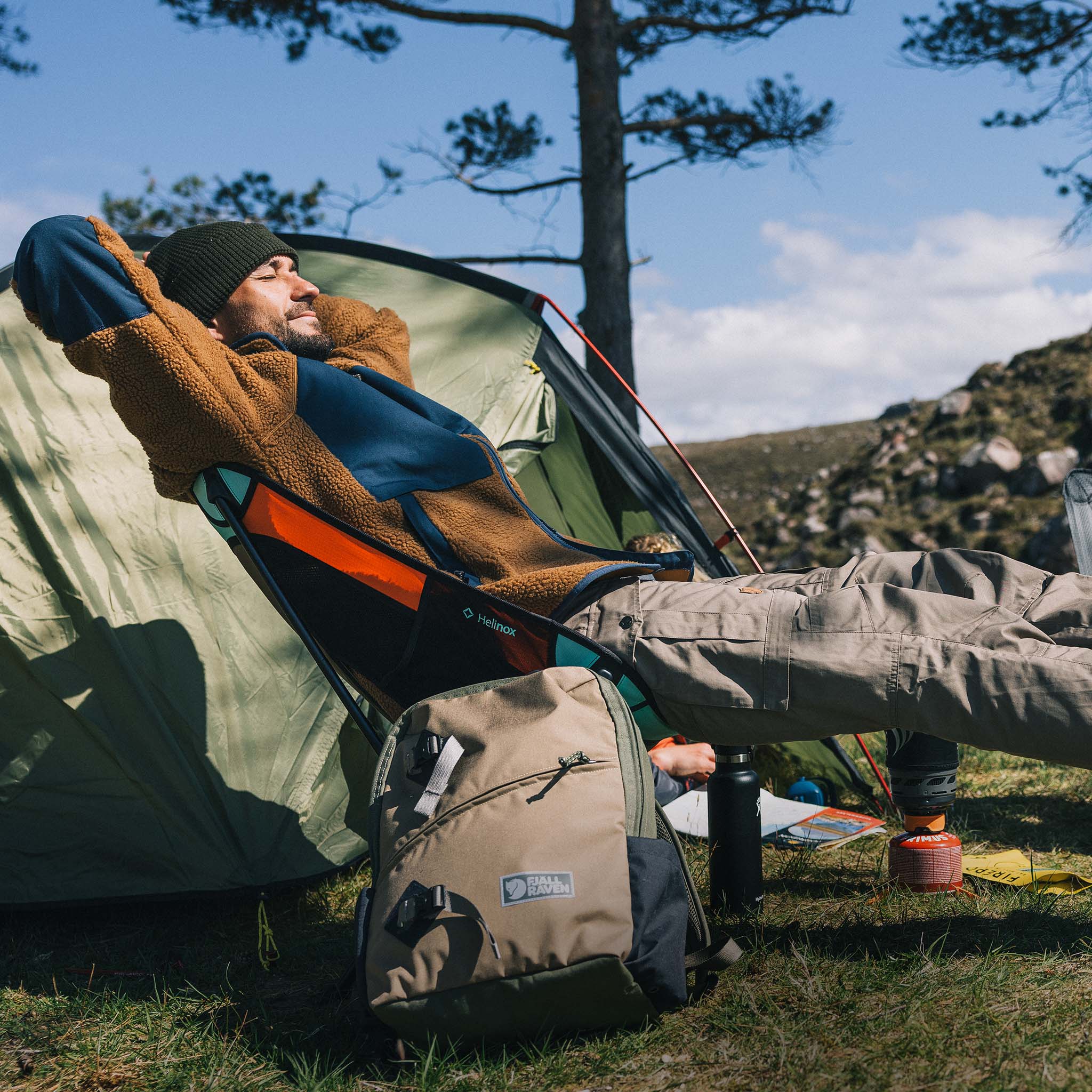Camper relaxing on his camping chair near his tent