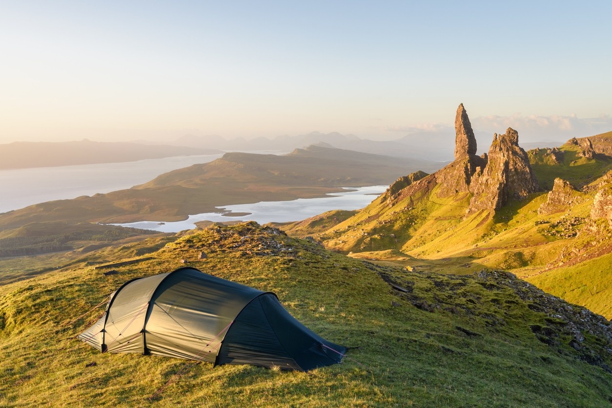 Green tent pitched in the mountains