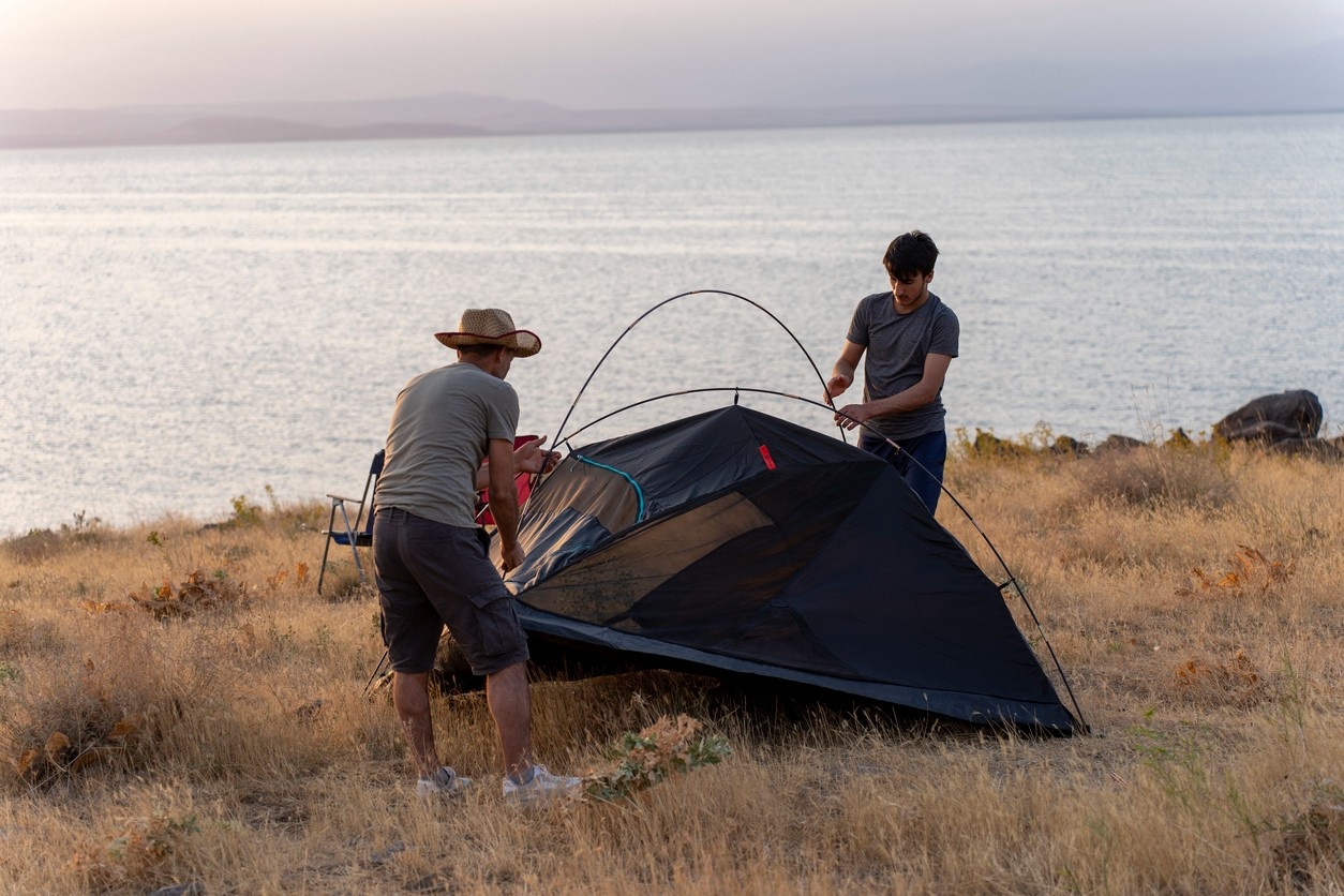An image of a father and son pitching their tent