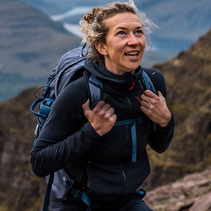 Shop women's outdoor gear. A woman on a hike in a fleece 
