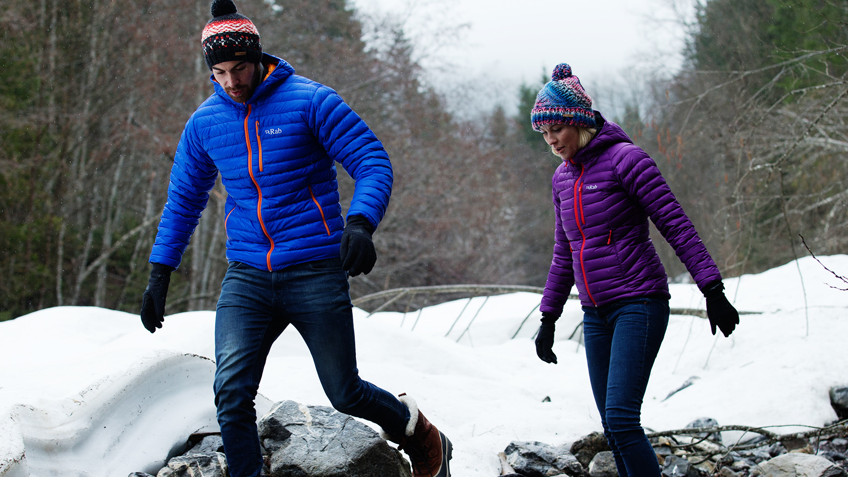 A couple walking in the snow in their insulated jackets 