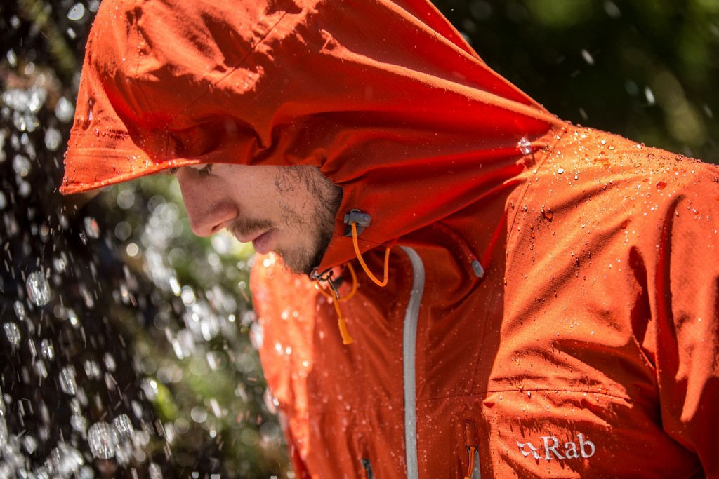 Menn wearing an orange waterproof jacket